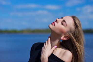 Güzel bir genç kızın portresi Gölün arka planına karşı.