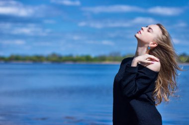 Güzel bir genç kızın portresi Gölün arka planına karşı.