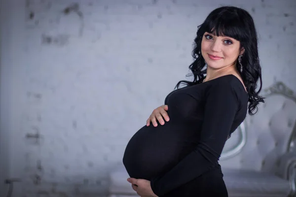 Uma Mulher Grávida Vestido Preto Contra Pano Fundo Paredes Cinzentas — Fotografia de Stock