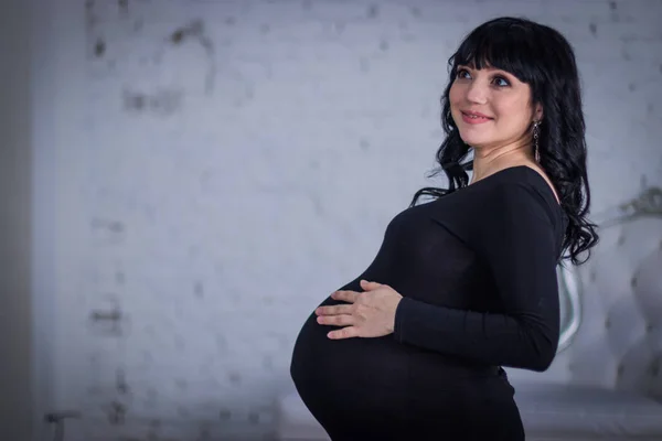 Uma Mulher Grávida Vestido Preto Contra Pano Fundo Paredes Cinzentas — Fotografia de Stock