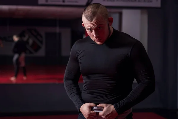 Kaslı adam ayna ile spor salonunda siyah t-shirt.