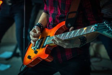 Adam gitar dizeleri parmaklar, yakın çekim çalıyor.