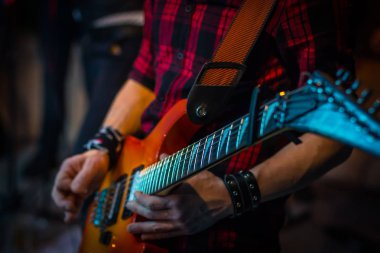 Adam gitar dizeleri parmaklar, yakın çekim çalıyor.