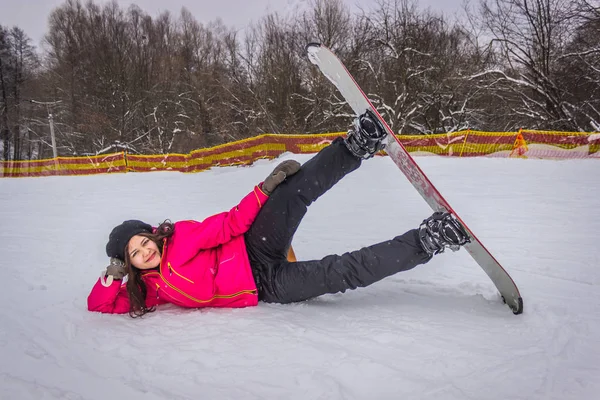 Linda Menina Snowboarder Deitado Neve Com Snowboard — Fotografia de Stock