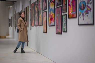 Güzel kız sanat galerisinde resim sergisi görünüyor