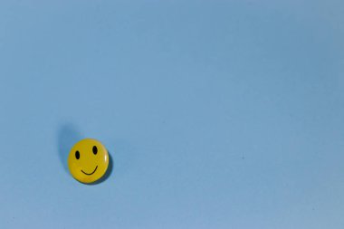 mavi bir arka plan üzerinde sarı gülümseyen.