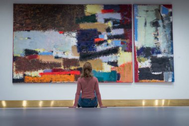 katta oturan kız ve dik dik bakıyor, modern Sanat Galerisi'nde resmi.