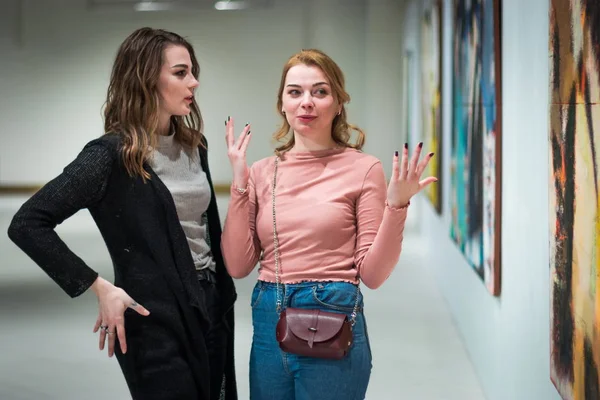 Две девушки обсуждают картины в Галерее современного искусства — стоковое фото