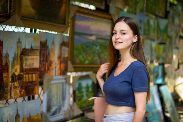 Vacker flicka undersöker målningar i galleriet — Stockfoto