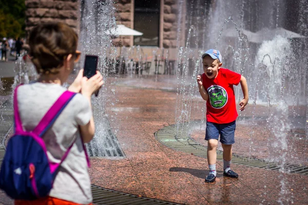 Moeder neemt foto's van haar zoon bij de fontein — Stockfoto