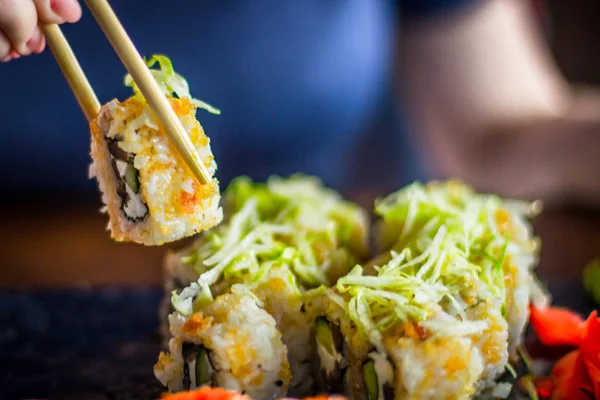Girl eats Japanese vegetarian rolls