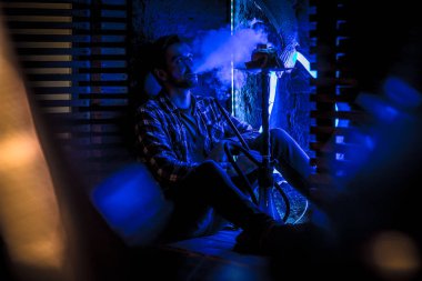 Genç adam nargile içiyor.