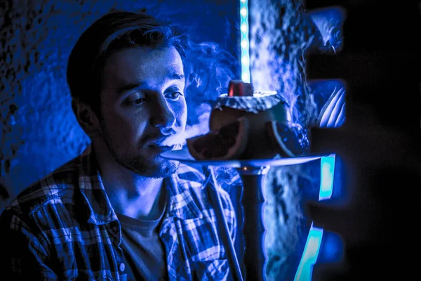Jovem cara fuma narguilé — Fotografia de Stock