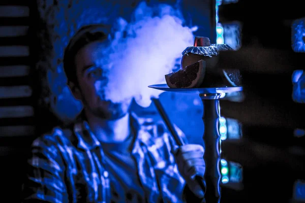 Jovem cara fuma narguilé — Fotografia de Stock