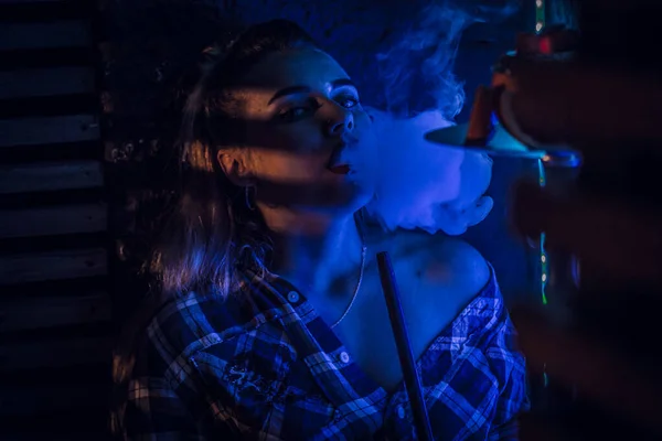 Beautiful girl smokes hookah