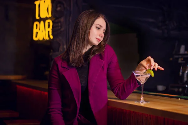 Μια όμορφη κοπέλα πίνει ένα κοκτέιλ στο μπαρ. — Φωτογραφία Αρχείου
