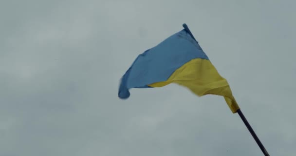 The big national flag of Ukraine flies in the blue sky. Big yellow blue Ukrainian state banner in the city of Dnipro, Dnipropetrovsk. Independence, Constitution Day, National Day, text space — Stock Video