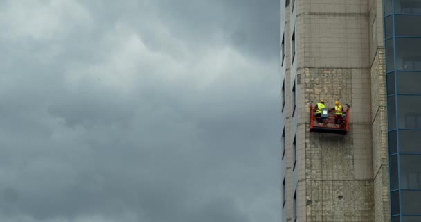 Equipo de limpiadores de ventanas fuera de las ventanas del edificio del rascador del cielo. La imagen también muestra el traje de seguridad y el instrumento . — Vídeos de Stock