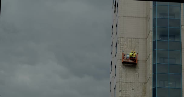 Team of windows cleaner outside the windows of sky scraper building. Picture also shows the safety suit and instrument. — Stock Video