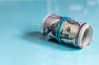 Amerikan dolarları toplandı ve açık mavi arka planda renkli bantlarla sıkılaştırıldı