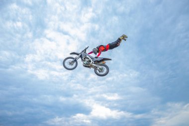 Motokros Sürücüsü Bulutlu mavi bir gökyüzüne atla