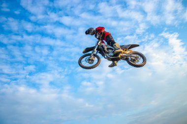 Motokros Sürücüsü Bulutlu mavi bir gökyüzüne atla