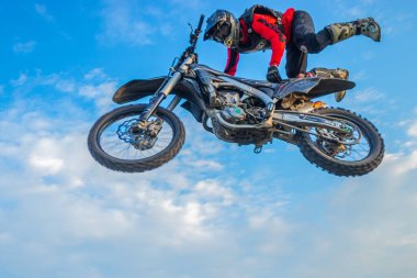 Motokros Sürücüsü Bulutlu mavi bir gökyüzüne atla