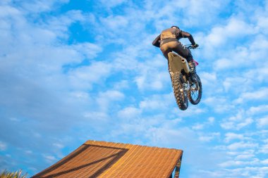 Profesyonel motokros sürücüsü fmx motorsiklet sürüyor, aşırı dublörlük yapıyor. Profesyonel motorcu atlıyor.