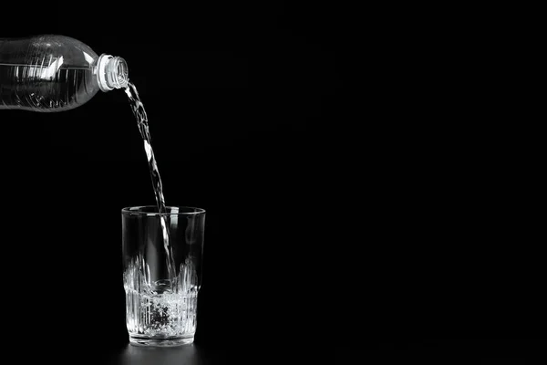 Gieten Van Water Een Glas Een Donkere Achtergrond — Stockfoto