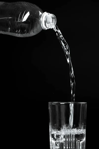 Versando Acqua Bicchiere Uno Sfondo Scuro — Foto Stock