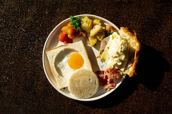 a fried egg Sunny Side Up and Croissant cheese served with SIDE DISH on a plate,for breakfast or coffee brake.