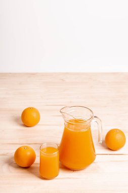 Cam ve ahşap masa üzerinde taze portakal ile taze portakal suyu kavanoz