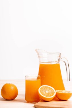 Cam ve ahşap masa üzerinde taze portakal ile taze portakal suyu kavanoz