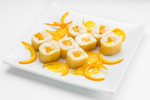 Dolce sushi roll dessert con arancia su un piatto bianco — Foto Stock