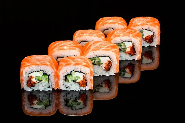 Rolo de sushi japonês tradicional com salmão defumado close-up isolado em um fundo preto — Fotografia de Stock