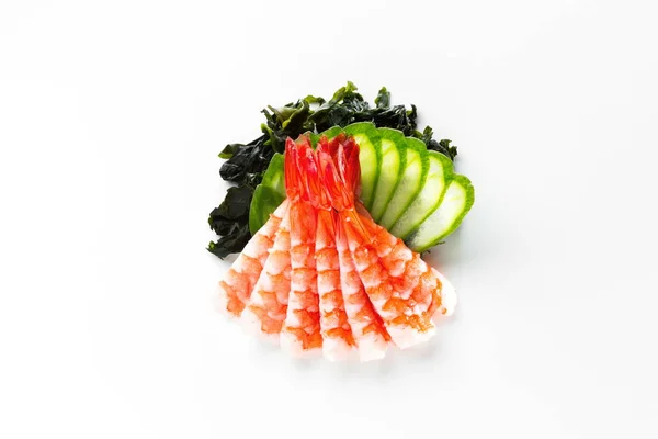 Traditionella japanska sashimi med räkor, sjögräs och gurka på en vit bakgrund ovanifrån — Stockfoto