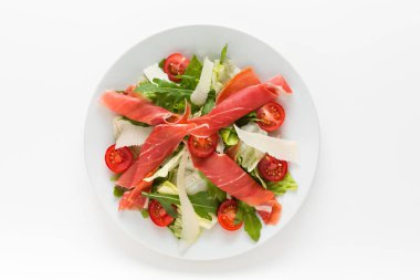 Taze salata ile beyaz bir arka plan üzerinde prosciutto jambonu, parmesan ve kiraz domates Üstten Görünüm