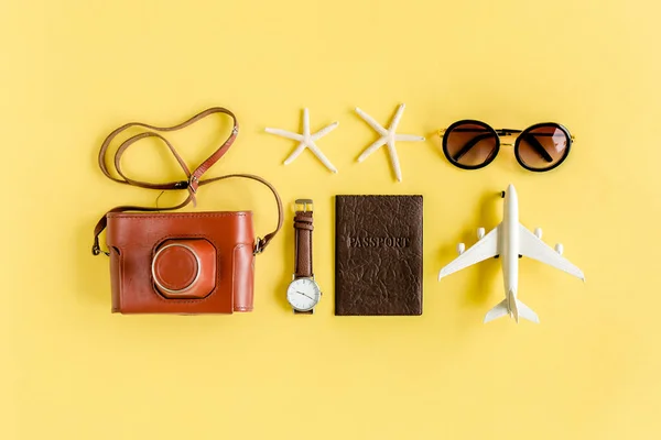 Resenärer tillbehör koncept på gul bakgrund. Retrokamera, modellplan, flygplan, solglasögon. Sommarbakgrund. — Stockfoto