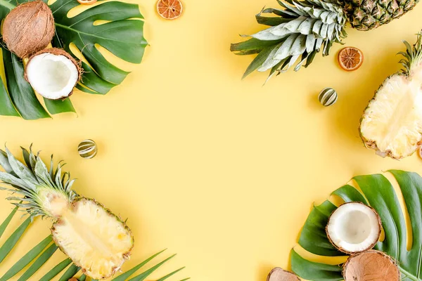Τροπικό πλαίσιο, φόντο με εξωτικά φρούτα και τροπικά φύλλα φοίνικα σε κίτρινο φόντο. Επίπεδο lay, πάνω όψη — Φωτογραφία Αρχείου