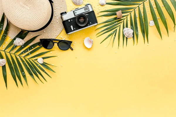 Accesorios para viajeros, ramas de hojas de palma tropicales sobre fondo amarillo con espacio vacío para texto. Fondo de verano. Piso tendido, vista superior. — Foto de Stock