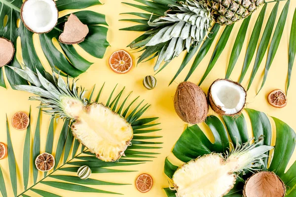 Motif tropical, fond avec des fruits exotiques et des feuilles de palmier tropical sur fond jaune. Couché plat, vue du dessus — Photo