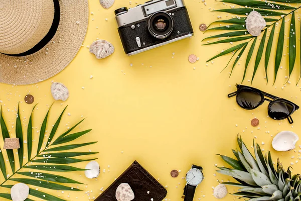 Accesorios para viajeros, ramas de hojas de palma tropicales sobre fondo amarillo con espacio vacío para texto. Fondo de verano. Piso tendido, vista superior. — Foto de Stock