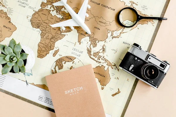 Planning vacation, travel plan, trip vacation using world map along with other travel accessories. Top view, flat lay.