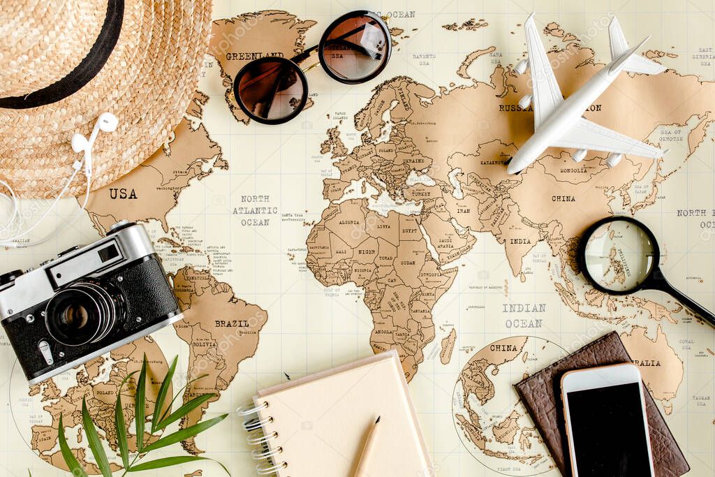 Planning vacation, travel plan, trip vacation using world map along with other travel accessories. Top view, flat lay. 