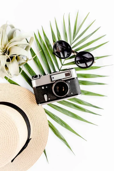 플랫은 흰색 배경에 역 카메라, 밀짚 모자, 선글라스, 열 대 야자나무 잎을 얹은 여행용 액세서리를 달았다. 여행 개념의 배경. — 스톡 사진