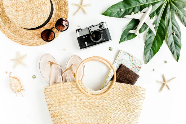 Kadın plaj aksesuarları: rattan çanta, hasır şapka, tropik palmiye yaprakları, beyaz arka planda uçak. Seyahat kavramı. Yaz arkaplanı. — Stok fotoğraf