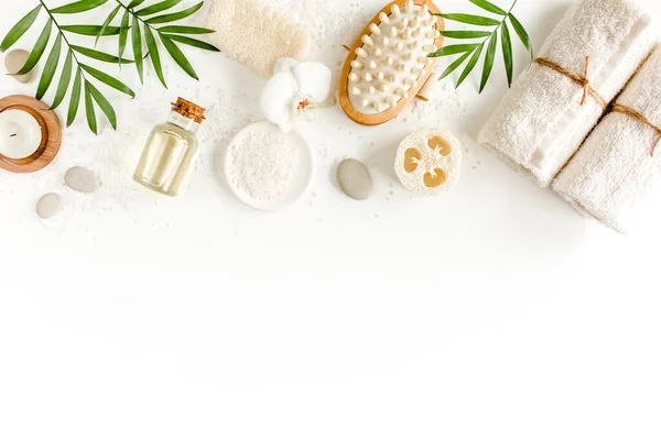 Spa arka planı. Doğal Organik Spa kozmetik ürünleri, çevre dostu banyo aksesuarları, palmiye yaprakları. Beyaz arka planda cilt konsepti. Düz yatıyordu