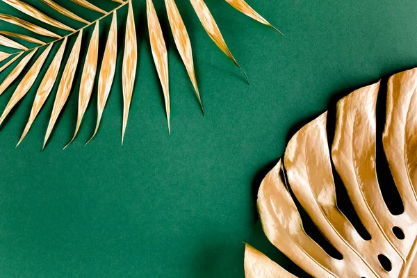 La palma tropical dorada deja a Monstera sobre fondo verde. Plano laico, vista superior concepto mínimo. — Foto de Stock