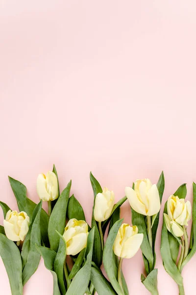 Bouquet di fiori di tulipano pastello e giallo su sfondo rosa. Posa piatta, vista dall'alto. Di San Valentino. Modello floreale — Foto Stock