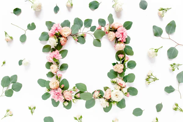 Cadre en roses et clous de girofle, feuilles vertes eucalyptus, branches, motif floral sur fond blanc. Couché à plat, vue de dessus. Valentines fond. — Photo